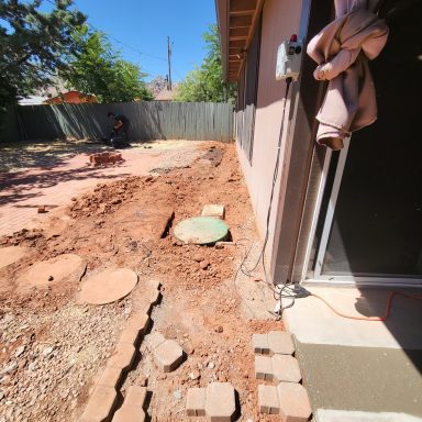 Exterior plumbing trench Trench alongside a home during plumbing work