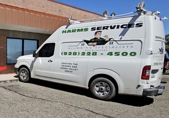 Harms Services service vehicle Harms Services work van beside a building