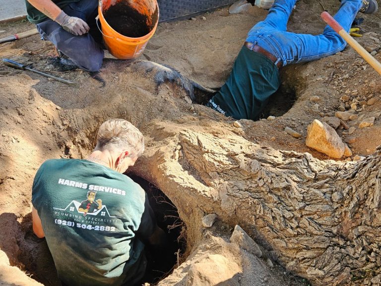 Plumbing work by Harms Services technicians Harms Services technicians working in an excavated plumbing trench