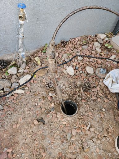 Underground pipe access Rocky ground with an exposed pipe opening