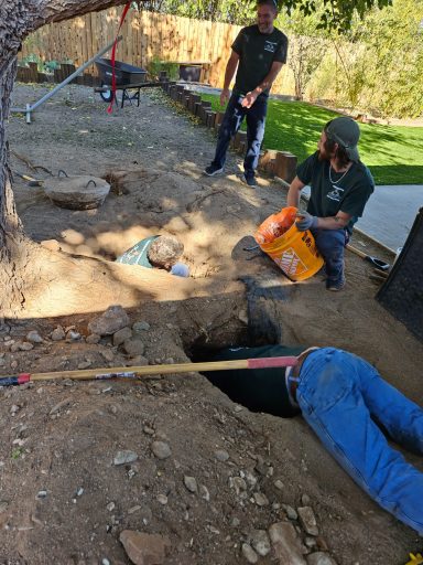Plumbing excavation work Technicians and digging equipment beside an open trench