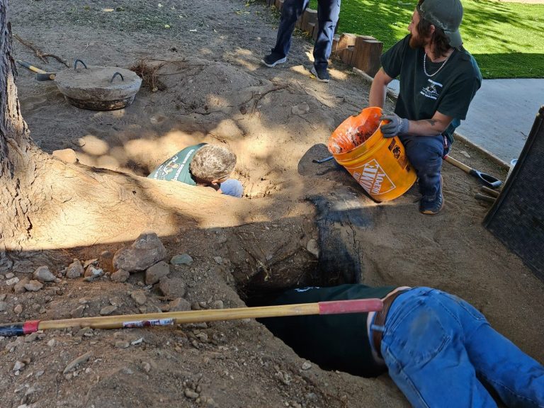 On-site plumbing work Technicians working at an excavated plumbing area