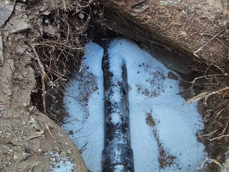 Underground pipe project photograph Exposed underground pipe in an excavated area with standing water