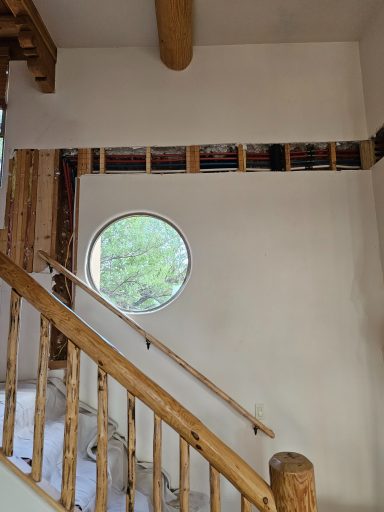 Interior wall access during renovation Open wall framing beside a stairway and round window