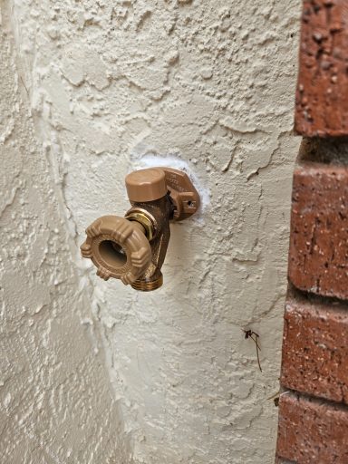 Outdoor hose faucet Outdoor hose faucet mounted on a stucco wall