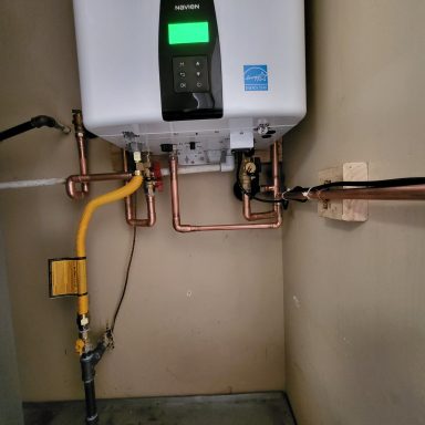 Tankless water heater installation Wall-mounted tankless water heater with connected piping
