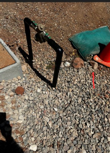 Tools at an excavation site Green work gloves and hand tools beside excavated soil